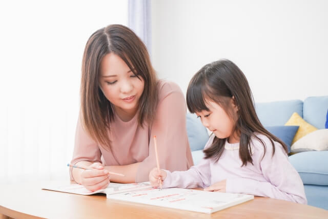 リビングで一緒に勉強する親子